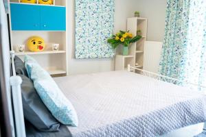 a bedroom with a white bed and blue curtains at Luxury Apartments in Platánion