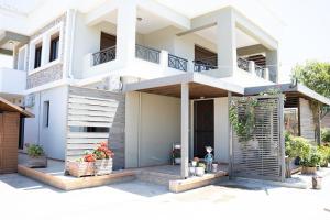 a white house with plants in front of it at Luxury Apartments in Platánion