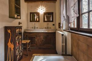 La salle de bains est pourvue d'une baignoire, d'un lavabo et d'un miroir. dans l'établissement 4BR Traditional Chalet BBQ + Fireplace + View, aux Houches