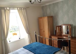 um quarto com uma cama e uma janela em Spacious rural cottage outside Campbeltown em Campbeltown