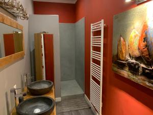 uma casa de banho com um lavatório e uma pintura na parede em Magnifique grand appartement em Orange