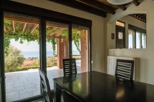 a dining room with a table and chairs with a view at Villa Aiolos in Alexandroupoli