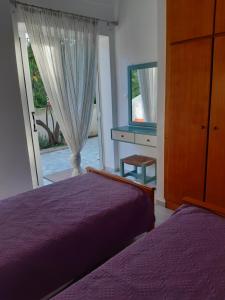 a bedroom with two beds and a dresser and a window at Renovated apartment in Adelianos Kampos in Adelianos Kampos
