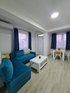 a living room with a blue couch and a table at Happy apartments Strumica in Strumica