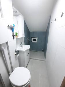 a bathroom with a white toilet and a sink at Happy apartments Strumica in Strumica