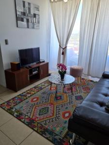 a living room with a couch and a table on a rug at Marina Sol 310 in Coquimbo