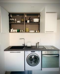 a kitchen with a washing machine and a sink at Dependence “Le Soleil” - Cap Riviera in Menton