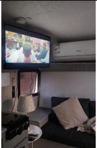 a living room with a tv and a couch at كرفان الياسمين in Al Hada