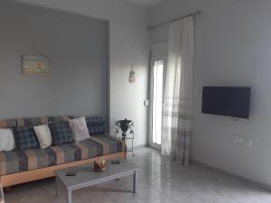 a living room with a couch and a tv at Renovated apartment in Adelianos Kampos in Adelianos Kampos