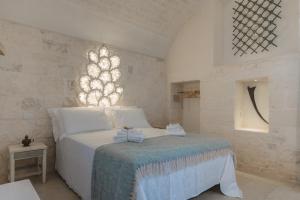 a bedroom with a white bed and a window at Borgo Altobello in Cisternino