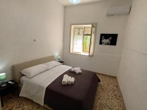 een slaapkamer met een bed met twee slippers erop bij Green Apartment in Sorrento coast in Massa Lubrense