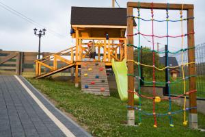 a child is sitting on a playset in a playground at DW KINGA & DOMKI na Granicznej z jacuzzi in Kacwin