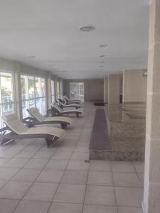 Porto Real Resort Suites 1 في مانغاراتيبا: صف من الكراسي الفارغة في مبنى كبير