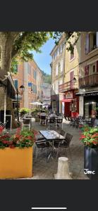 an outdoor patio with tables and chairs and flowers at Véritable Suite d'Hotel! in Orange