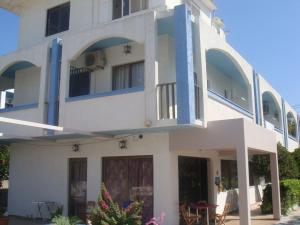 a white building with blue balconies on it at Omiros in Faliraki