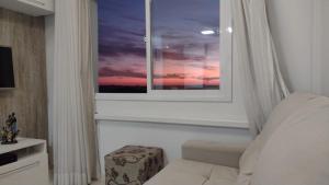 a bedroom with a window with a sunset at Apto super aconchegante/linda vista para Vale dos Vinhedos in Bento Gonçalves