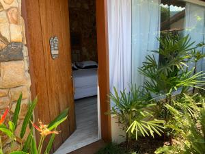 Almas Gêmeas suíte com cozinha praia da Ribeira في انغرا دوس ريس: باب مفتوح لغرفة بها نباتات في الأمام