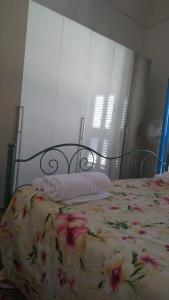 a bed with a floral bedspread with towels on it at The Twins rooms in Marettimo 1 in Marettimo