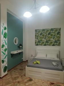 1 dormitorio con 1 cama con una pintura en la pared en Da Nonna Maria Apt 1 or Apt 2, en Terrasini