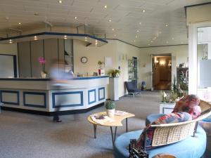 a lobby with a bar in the middle of a room at Hotel Friesische Wehde in Bockhorn