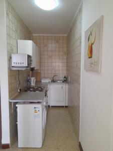 una pequeña cocina con fregadero y microondas en Sunshine Holiday Apartment 4 Next to the Sea, en St Paul's Bay