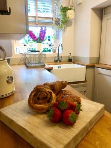 a plate of strawberries and a pastry on a cutting board at The Old Studio in Knaresborough