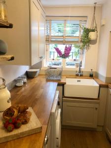 uma cozinha com um lavatório e uma tábua de cortar em The Old Studio em Knaresborough