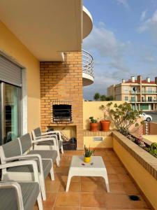 un patio con sillas y un balcón con chimenea en casa da praia azul, en Torres Vedras