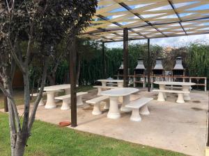 un gruppo di tavoli da picnic bianchi sotto una tettoia di Beautiful Apartment in paradisiac Praia da Rocha a Portimão