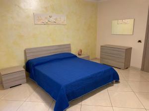 um quarto com uma cama azul e duas mesas de cabeceira em Soffio di Sicilia em Érice