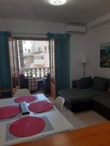 un soggiorno con divano e ombrelloni rossi su un tavolo di Apartament Nicoletta Costa Blanca Torrevieja a Torrevieja