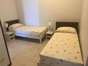 dwa łóżka w pokoju z dwoma łóżkami w obiekcie Appartamento miralago w mieście Stresa