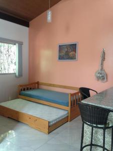 Schlafzimmer mit einem Bett und einem Tisch in der Unterkunft Chalé Verde - Vale do Capão in Vale do Capao