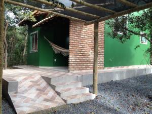 ein Backsteinhaus mit einer grünen Wand und einer Treppe in der Unterkunft Chalé Verde - Vale do Capão in Vale do Capao