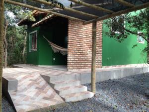 een stenen huis met een groene muur en een trap bij Chalé Verde - Vale do Capão in Vale do Capao