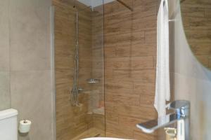 eine Dusche mit Glastür im Bad in der Unterkunft @LAKE STUDIO in Ioannina