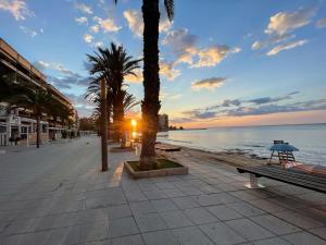 una strada con palme e un tramonto sulla spiaggia di Apartament Nicoletta Costa Blanca Torrevieja a Torrevieja