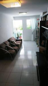 una sala de estar con sofá y una habitación con puerta en Quarto Individual para 3 Pessoas em AP Compartilhado, en João Pessoa