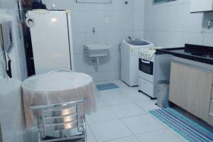 a white kitchen with a sink and a toilet at Quarto Individual para 3 Pessoas em AP Compartilhado in João Pessoa