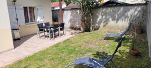 een patio met stoelen en een tafel in de tuin bij charmant studio de 30 m2 très calme avec sa grande belle terrasse et son jardin PRIVATIF in Tremblay En France