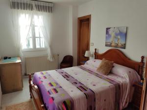 ein Schlafzimmer mit einem großen Bett mit einer bunten Decke in der Unterkunft PRECIOSA CASA DE 4 HABITACIONES EN PLENO CORAZÓN DEL CAMINO DE SANTIAGO! in Palas de Rei