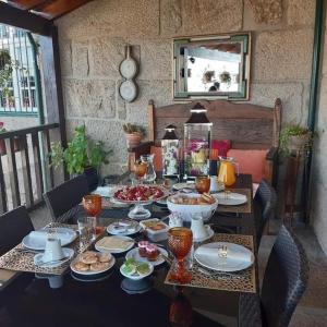 a table with plates and bowls of food on it at Casa do Adro de Parada in Parada de Pinhão