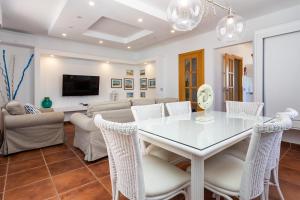 a dining room and living room with a table and chairs at Villa Leonor - Mirador de las Dunas in Corralejo
