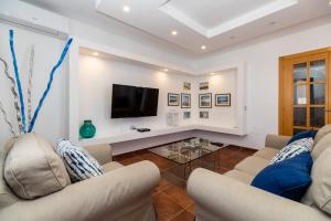 a living room with two couches and a tv at Villa Leonor - Mirador de las Dunas in Corralejo