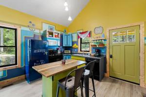 una cocina con paredes azules y amarillas y una puerta verde en Peace Pad, en Mills River