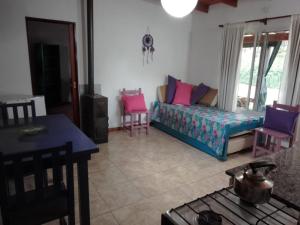 ein Wohnzimmer mit einem Sofa und einem Tisch in der Unterkunft Árbol de Oro - Terrafirme in Villa Yacanto