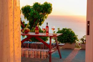 una mesa con 2 copas de vino en el balcón en Sette Isole Countryside Apartment en Athanion
