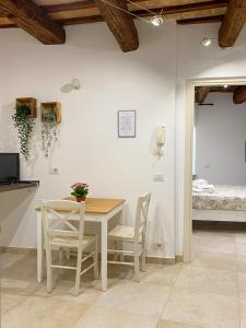 a dining room with a table and chairs and a bed at La Casa di LEO - Apartments in Recanati