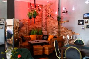 Habitación con sofá y pared de ladrillo en Nata Pokoje Gościnne Restauracja en Libiąż