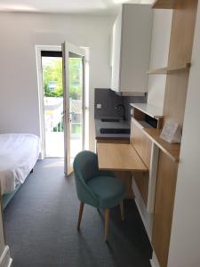 a room with a desk and a chair and a bed at Guesthaus 2 in Dudelange
